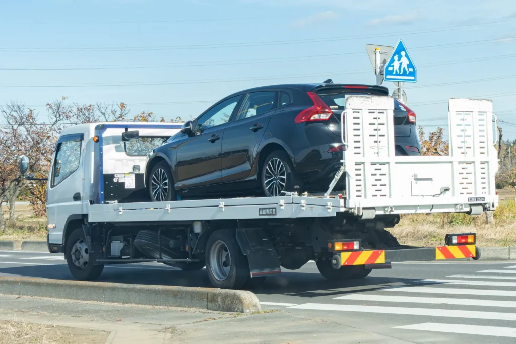 レッカー車で乗用車を移動している様子