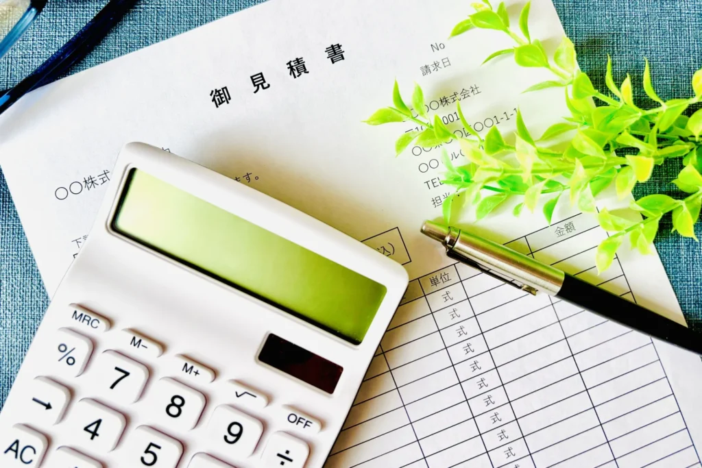 御見積書の上に電卓とペンがおかれた画像