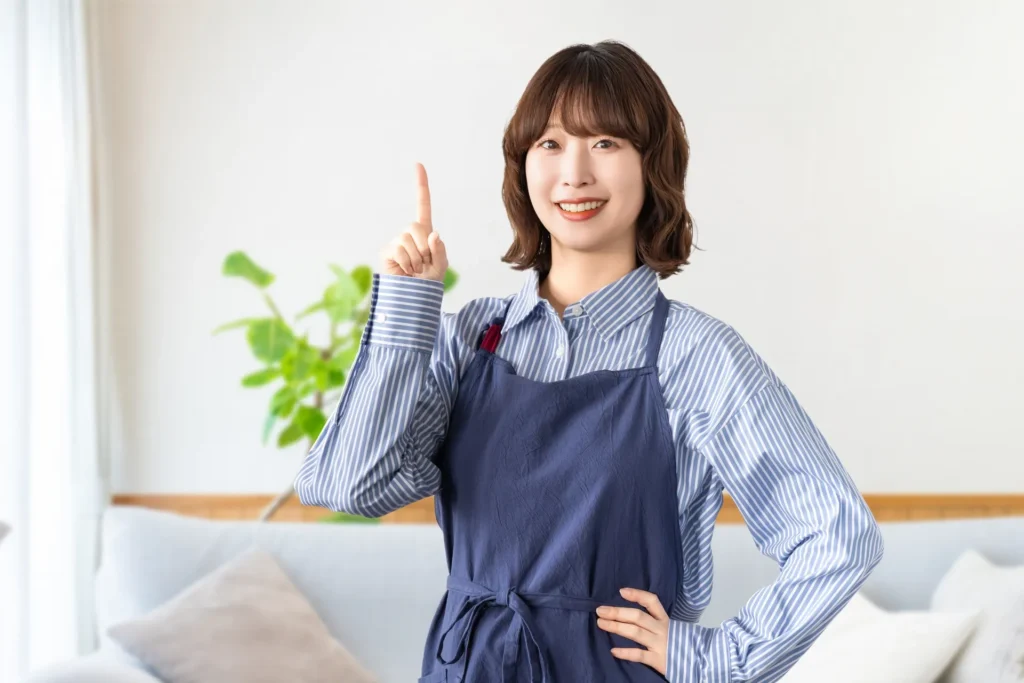エプロンを着た女性が人差し指を指している様子