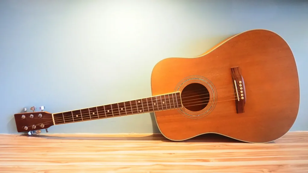 アコースティックギターを壁に立てかけた様子