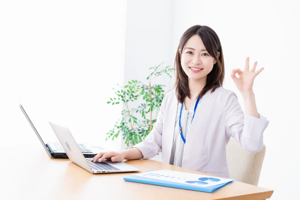 カメラ目線でOKマークを作る笑顔の女性