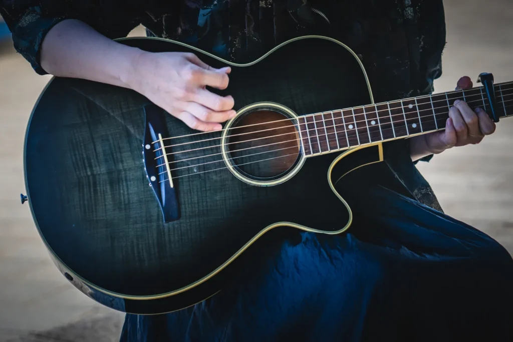 男性がアコースティックギターを演奏している様子